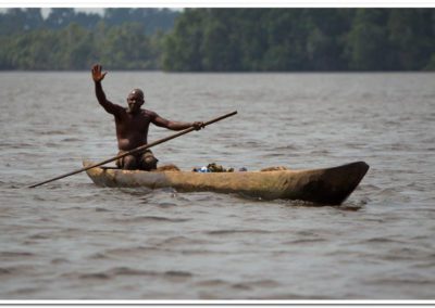 a man in a canoe on the river waving